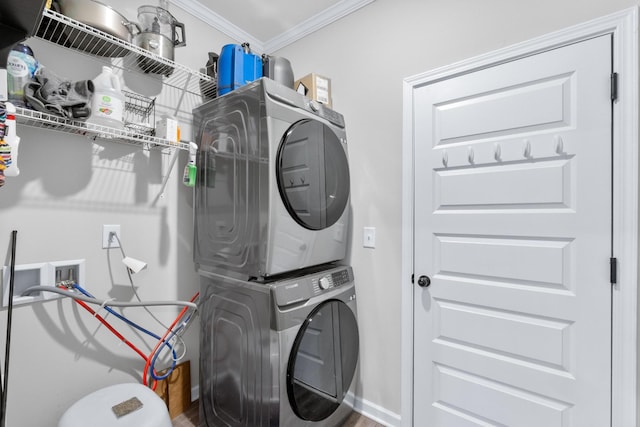 washroom featuring stacked washer and clothes dryer, laundry area, wood finished floors, and ornamental molding