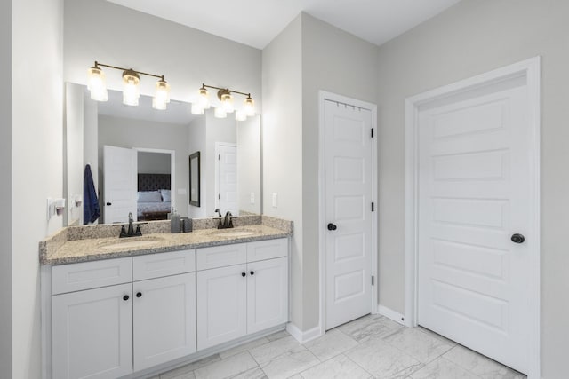 full bathroom with marble finish floor, ensuite bathroom, double vanity, and a sink