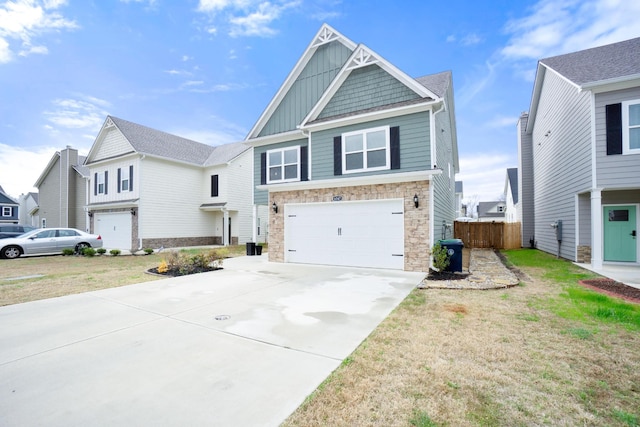 craftsman-style home with fence, an attached garage, stone siding, driveway, and board and batten siding