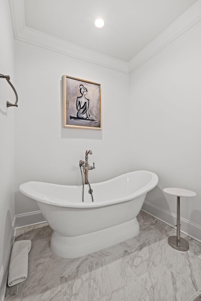 bathroom featuring crown molding, baseboards, a freestanding bath, and marble finish floor
