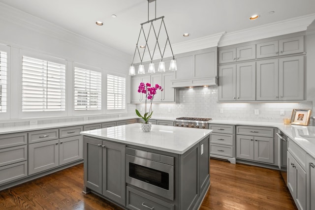 kitchen featuring crown molding, stainless steel appliances, gray cabinetry, and decorative backsplash