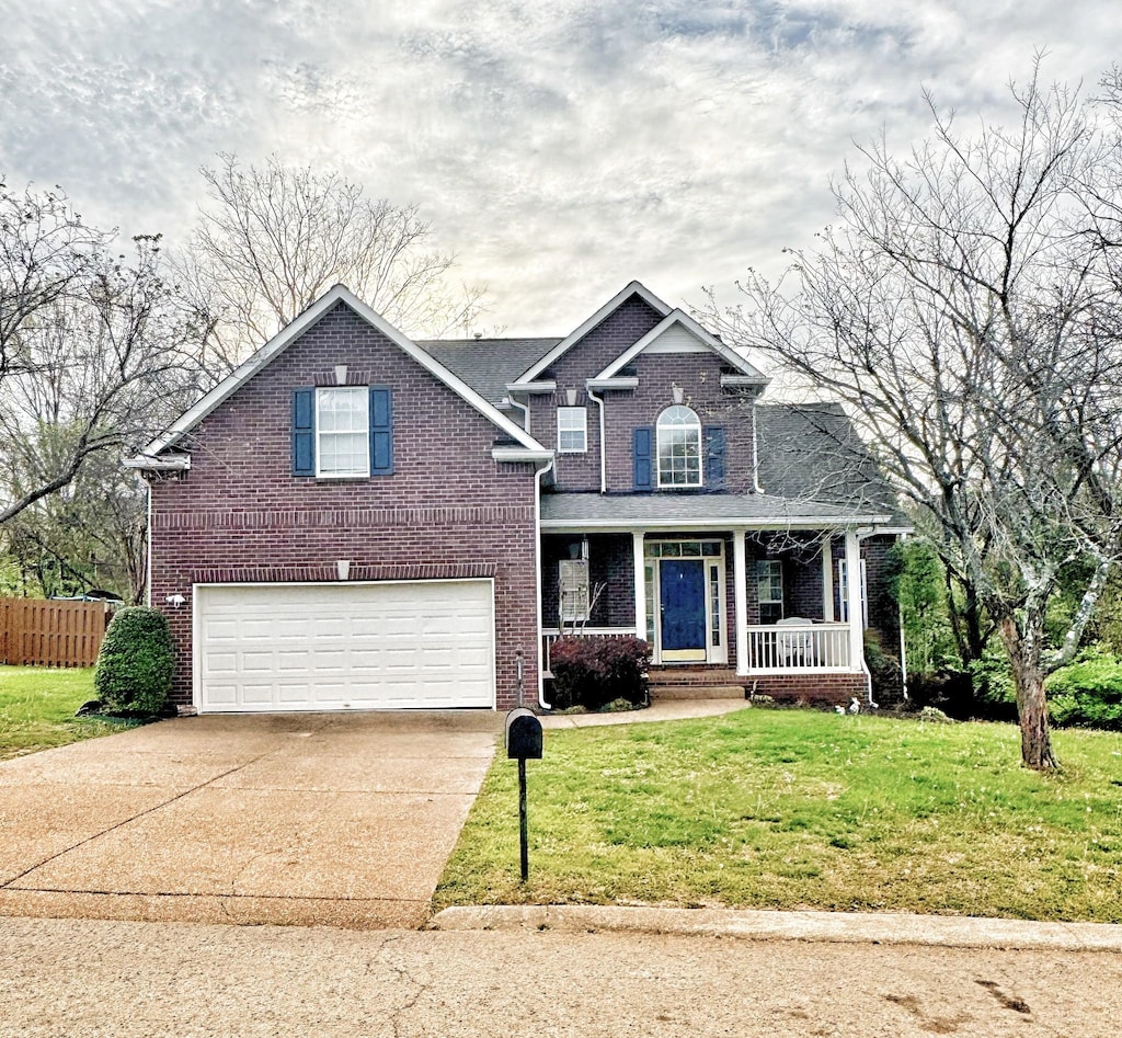 view of front of house featuring driveway, brick siding, an attached garage, a porch, and a front lawn