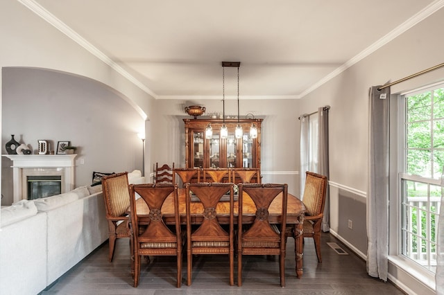 1040 Mansker Farm Blvd, Hendersonville, TN 37075 - dining area with crown molding, dark wood finished floors, arched walkways, a glass covered fireplace, and baseboards