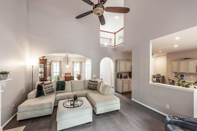 1040 Mansker Farm Blvd, Hendersonville, TN 37075 - living room featuring arched walkways, a ceiling fan, a high ceiling, dark wood-style flooring, and baseboards