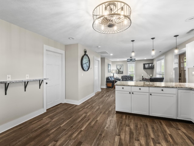 kitchen featuring baseboards, dark wood-style flooring, and light stone countertops