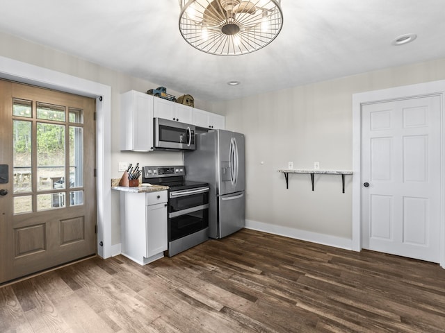 kitchen with white cabinetry, baseboards, appliances with stainless steel finishes, and dark wood-type flooring