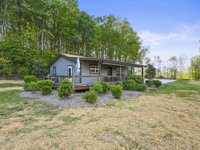 view of front of house with a wooden deck and a front yard