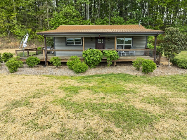 view of front of house with a front lawn, covered porch, and metal roof