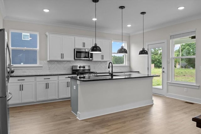 kitchen with backsplash, dark countertops, stainless steel appliances, and a sink