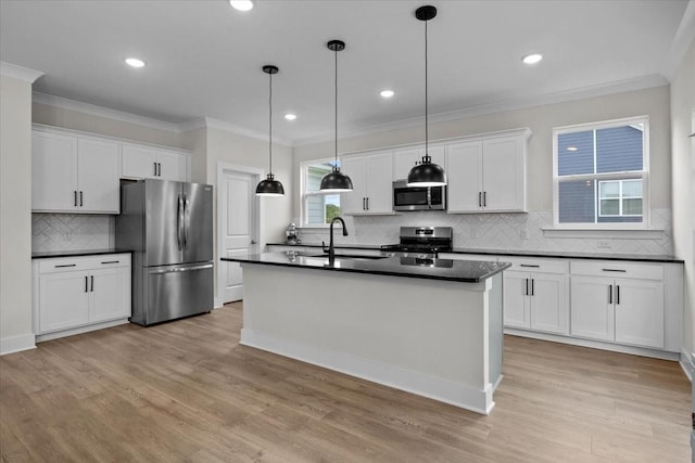 kitchen with a sink, stainless steel appliances, tasteful backsplash, ornamental molding, and dark countertops