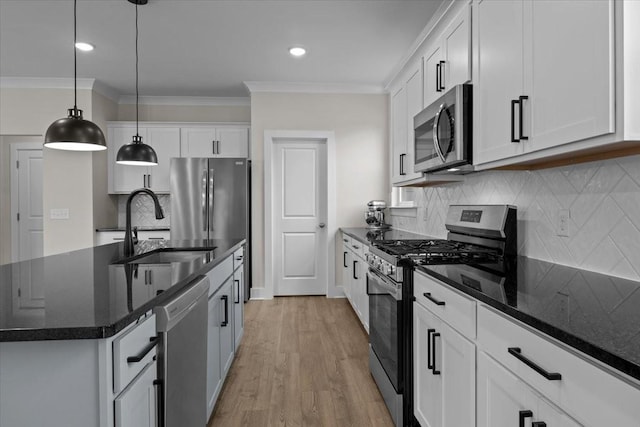 kitchen featuring a sink, crown molding, backsplash, white cabinetry, and appliances with stainless steel finishes