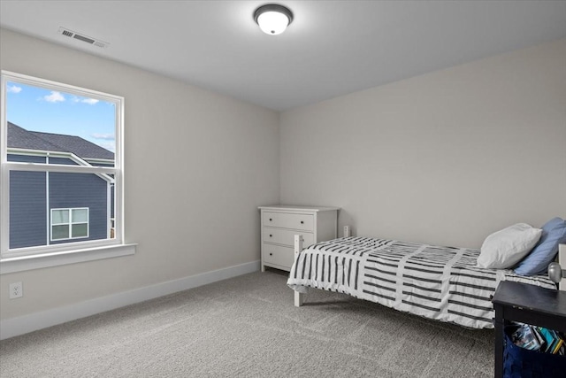 carpeted bedroom featuring baseboards and visible vents