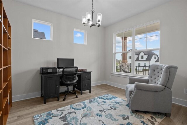 home office with an inviting chandelier, a wealth of natural light, and baseboards