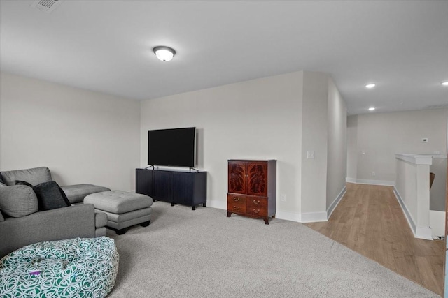 living room with recessed lighting, baseboards, light wood finished floors, visible vents, and light carpet