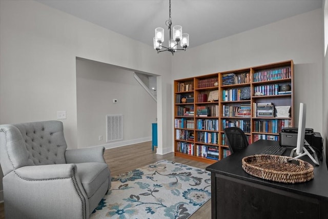 sitting room with wood finished floors, a chandelier, and baseboards