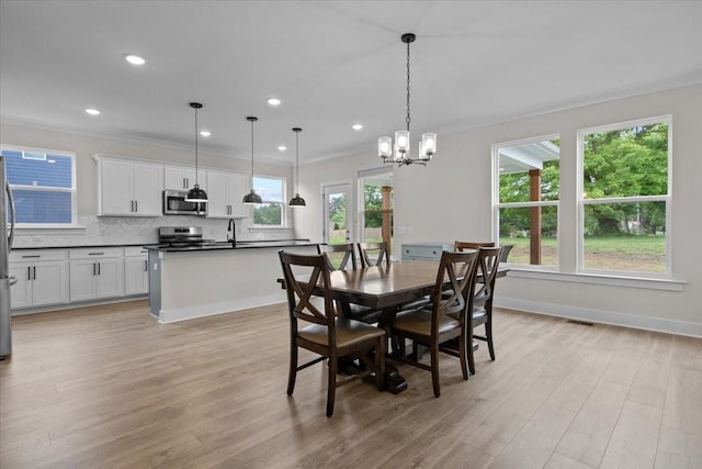 dining space featuring light wood-style flooring, a notable chandelier, and recessed lighting