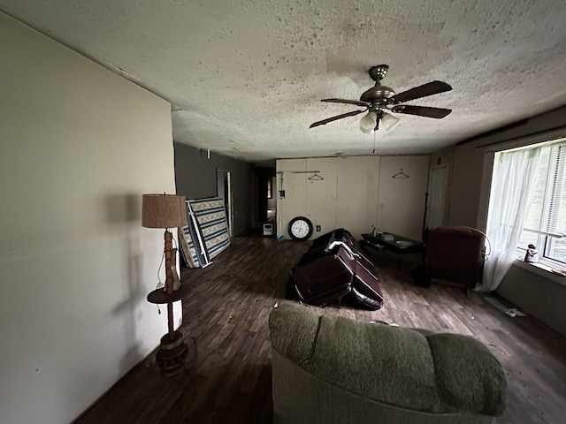 living room with ceiling fan, a textured ceiling, and wood finished floors
