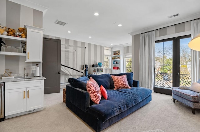 living area featuring light carpet, visible vents, and wallpapered walls