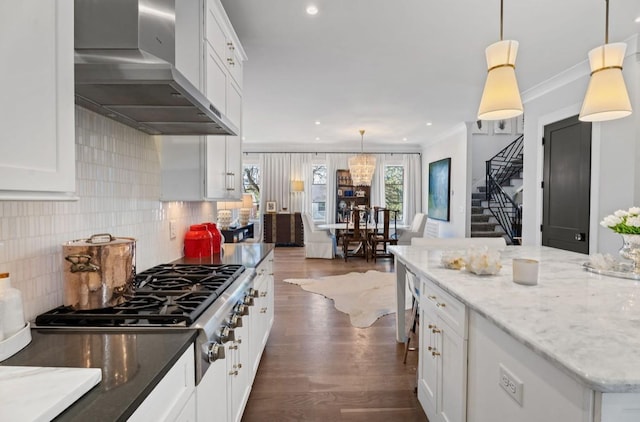 kitchen featuring tasteful backsplash, stainless steel gas stovetop, wall chimney exhaust hood, white cabinetry, and dark wood-style floors