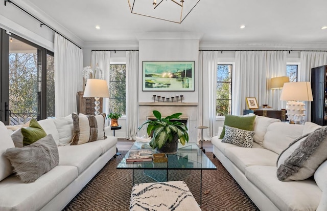living room featuring crown molding, wood finished floors, an inviting chandelier, and recessed lighting