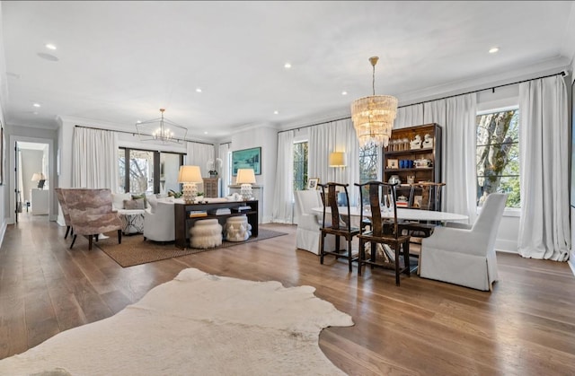 living area with crown molding, a wealth of natural light, and a notable chandelier