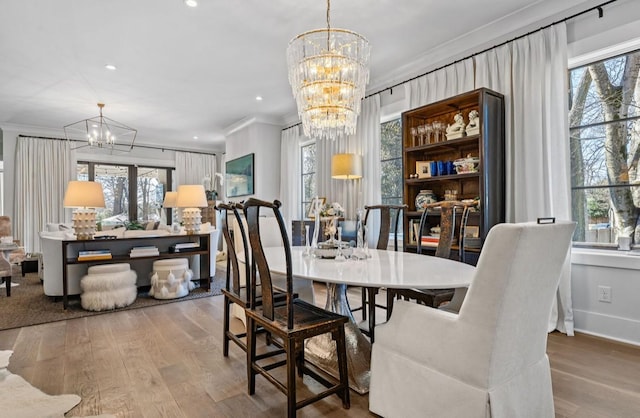 dining room featuring a wealth of natural light, a chandelier, crown molding, and wood finished floors