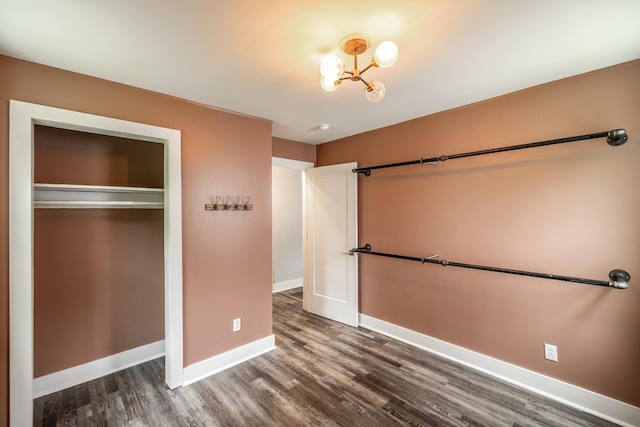 709 Ann Ave, Gallatin, TN 37066 - unfurnished bedroom with an inviting chandelier, dark wood-type flooring, baseboards, and a closet