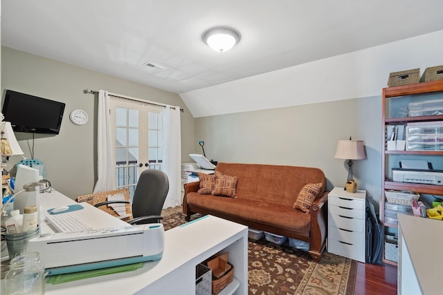 office space featuring lofted ceiling, visible vents, and wood finished floors