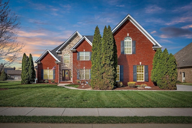 traditional-style home featuring brick siding and a front lawn