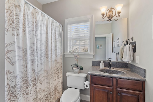 bathroom featuring toilet, an inviting chandelier, and vanity