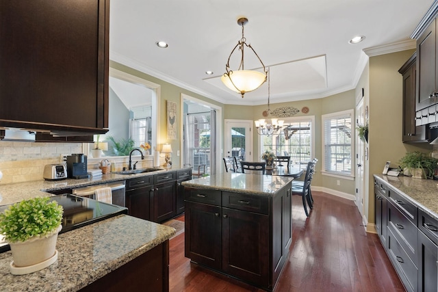 kitchen featuring a healthy amount of sunlight, a center island, decorative backsplash, and a sink
