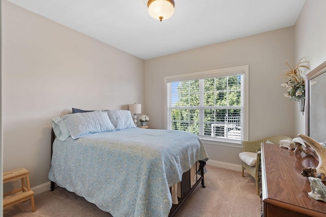 bedroom with light carpet and baseboards