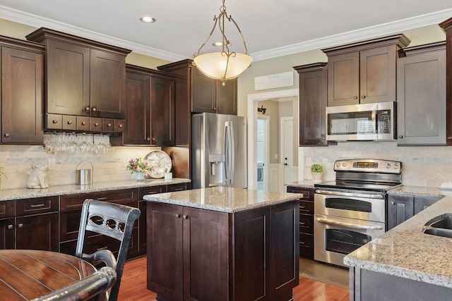 kitchen featuring dark brown cabinetry, appliances with stainless steel finishes, wood finished floors, and tasteful backsplash