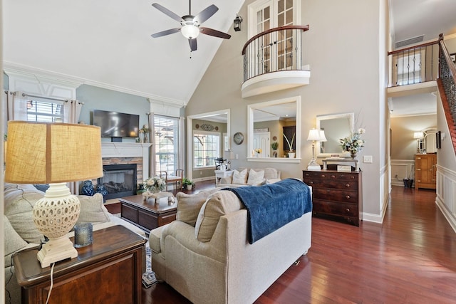 living room with ceiling fan, a towering ceiling, a wealth of natural light, and dark wood-style floors