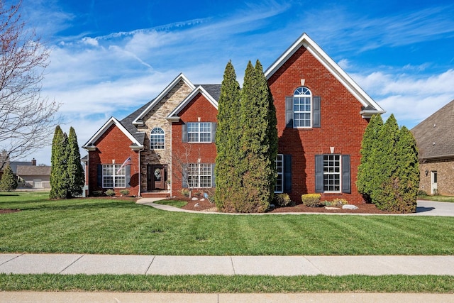 traditional-style house featuring a front lawn and brick siding