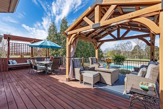deck with outdoor dining area, a gazebo, a fenced in pool, and an outdoor living space