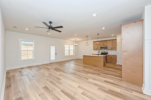 unfurnished living room featuring a sink, visible vents, recessed lighting, a ceiling fan, and light wood-style floors