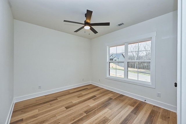 unfurnished room with baseboards, ceiling fan, light wood-style floors, and visible vents
