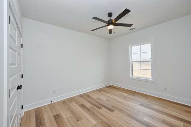 unfurnished room featuring light wood finished floors, baseboards, a ceiling fan, and visible vents