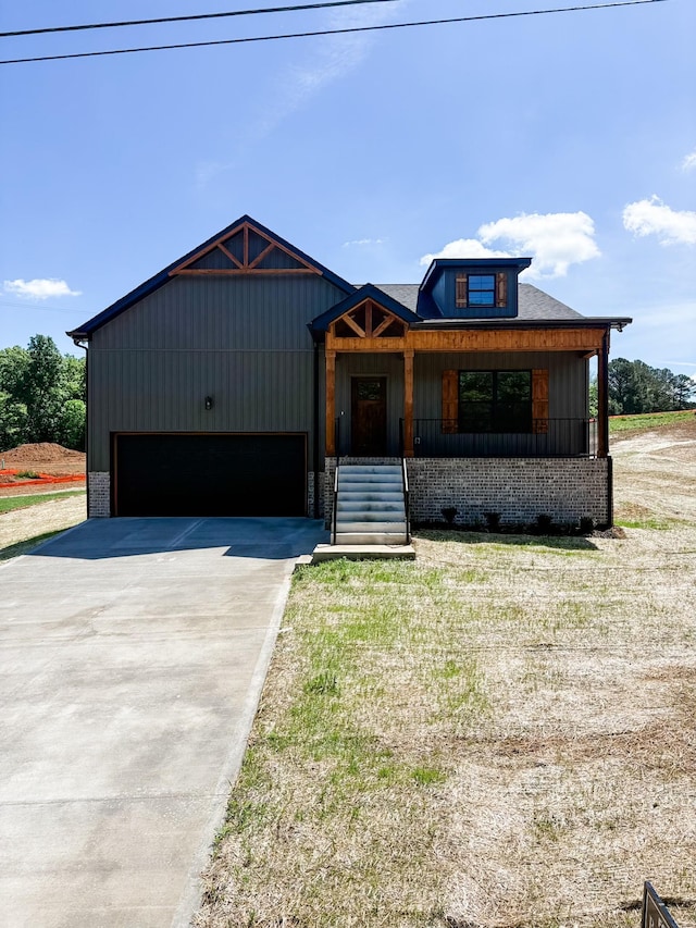 view of front of home featuring covered porch, an attached garage, and driveway