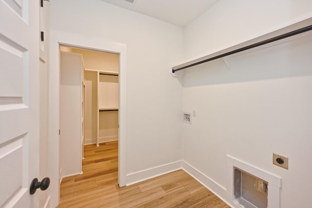 clothes washing area featuring light wood finished floors, electric dryer hookup, laundry area, washer hookup, and baseboards