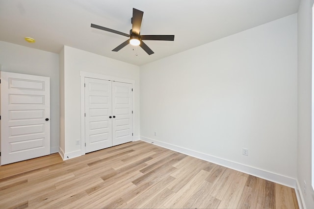 unfurnished bedroom with a closet, light wood-type flooring, baseboards, and ceiling fan