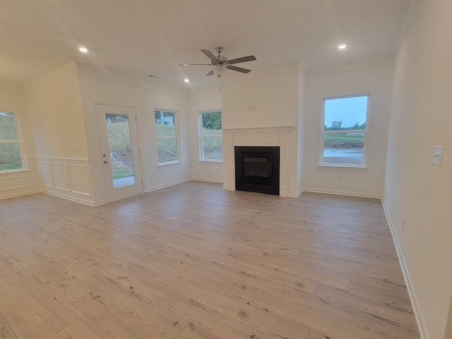 unfurnished living room with ornamental molding, recessed lighting, light wood-style flooring, a ceiling fan, and a glass covered fireplace