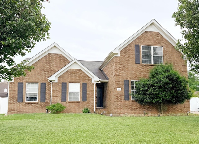 view of front of house with brick siding and a front lawn