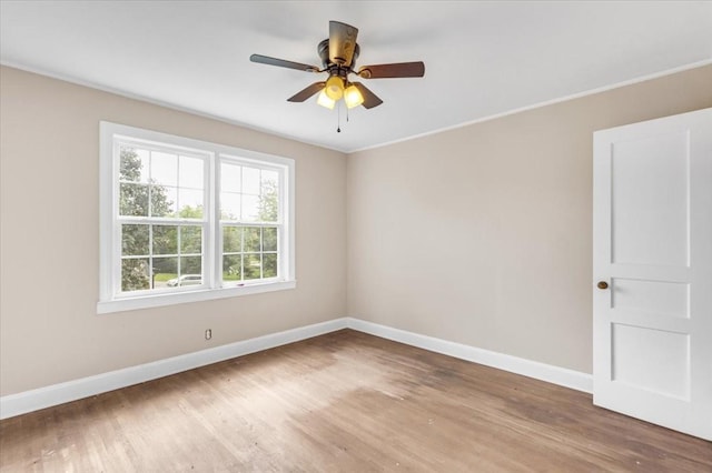 unfurnished room with baseboards, plenty of natural light, and wood finished floors