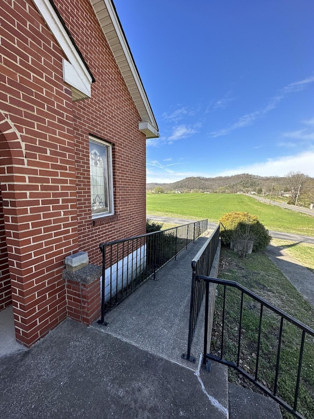 view of patio / terrace featuring a mountain view, a rural view, and fence