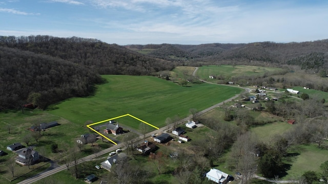 drone / aerial view with a wooded view and a rural view