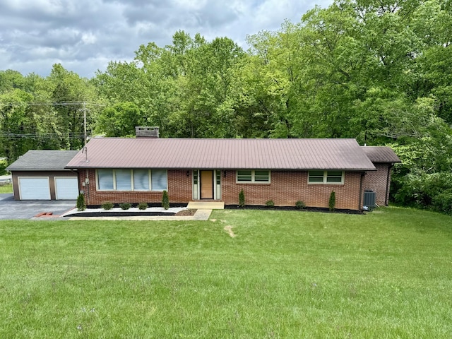 ranch-style home featuring driveway, brick siding, and a front lawn