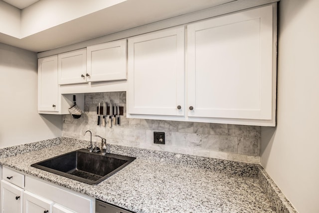 kitchen featuring white cabinetry, a sink, and tasteful backsplash