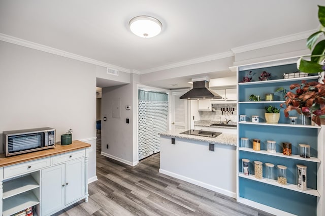 kitchen featuring open shelves, range hood, black electric cooktop, stainless steel microwave, and wood finished floors